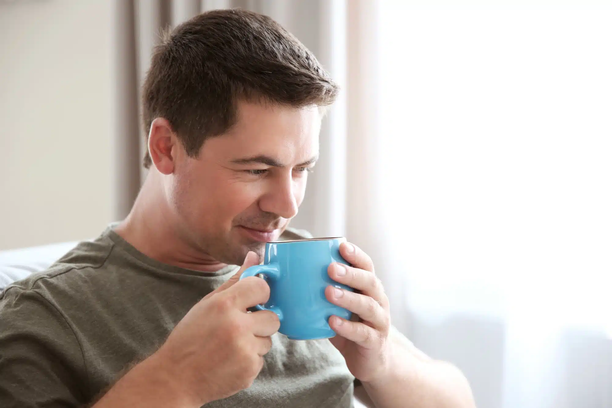 A man drinking kratom tea in a cup