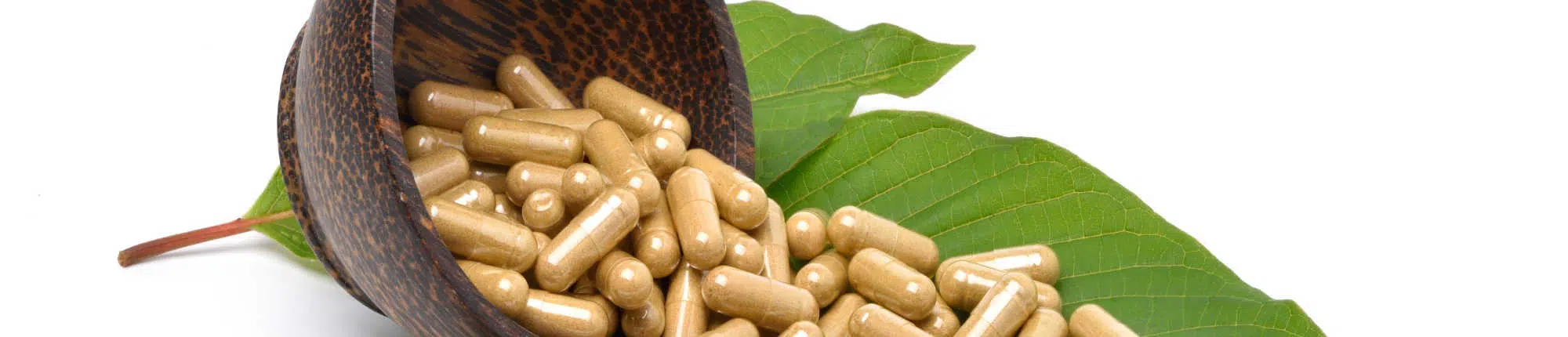 Kratom capsules spilling out of bowl